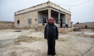 Un hombre frente a la casa rehabilitada de su familia en la zona rural del sur de Alepo (Siria).