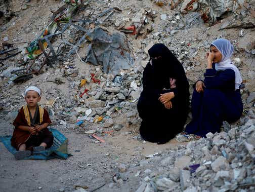 Les Palestiniens assistent aux prières d'Eid al-Adha près des ruines de la mosquée al-Al Rahma détruites par les frappes aériennes israéliennes, dans le contexte du conflit Israël-Hamas, à Khan Younis, dans le sud de la bande de Gaza, le 16 juin 2024. REUTERS/Mohammed Salem IMAGES TPX DU JOUR