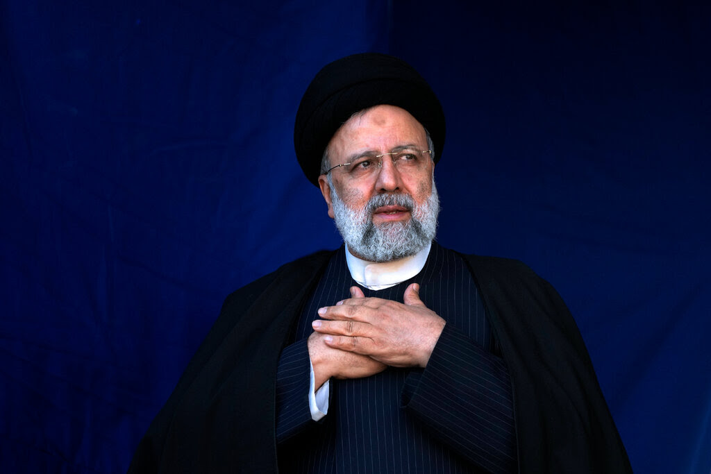President Ebrahim Raisi of Iran wears a black robe with a white collar.