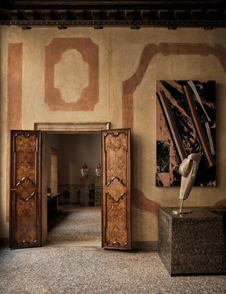 Obra de arte de Sterling Ruby y una escultura de De Cotiis hecha de fibra de vidrio pintada a mano y latón fundido en la sala de estar.