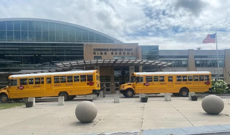 Two school buses in front of a high school