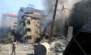 Una mujer camina frente a un edificio destruido por los bombardeos israelíes en el sur de Beirut.