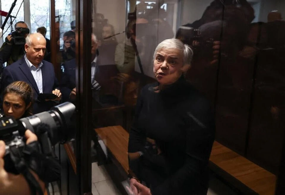 Nadezhda Buyanova stands inside an enclosure for defendants during a court hearing in Moscow