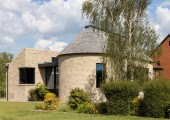 Los volúmenes de bordes curvos y ladrillo visto presentan una armonía visual con la vivienda original.