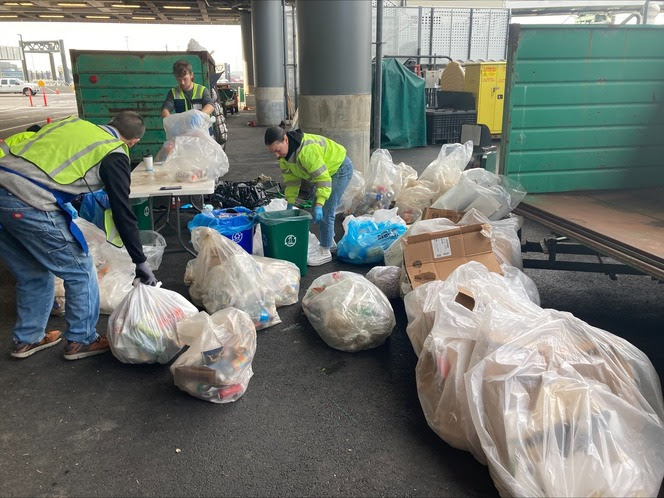 People sorting bags of trash at Colman Dock in Seattle