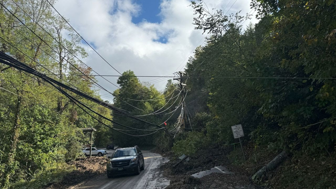 A vehicle drives underneath low-hanging power lines in Elk Park, North Carolina, on Sunday.