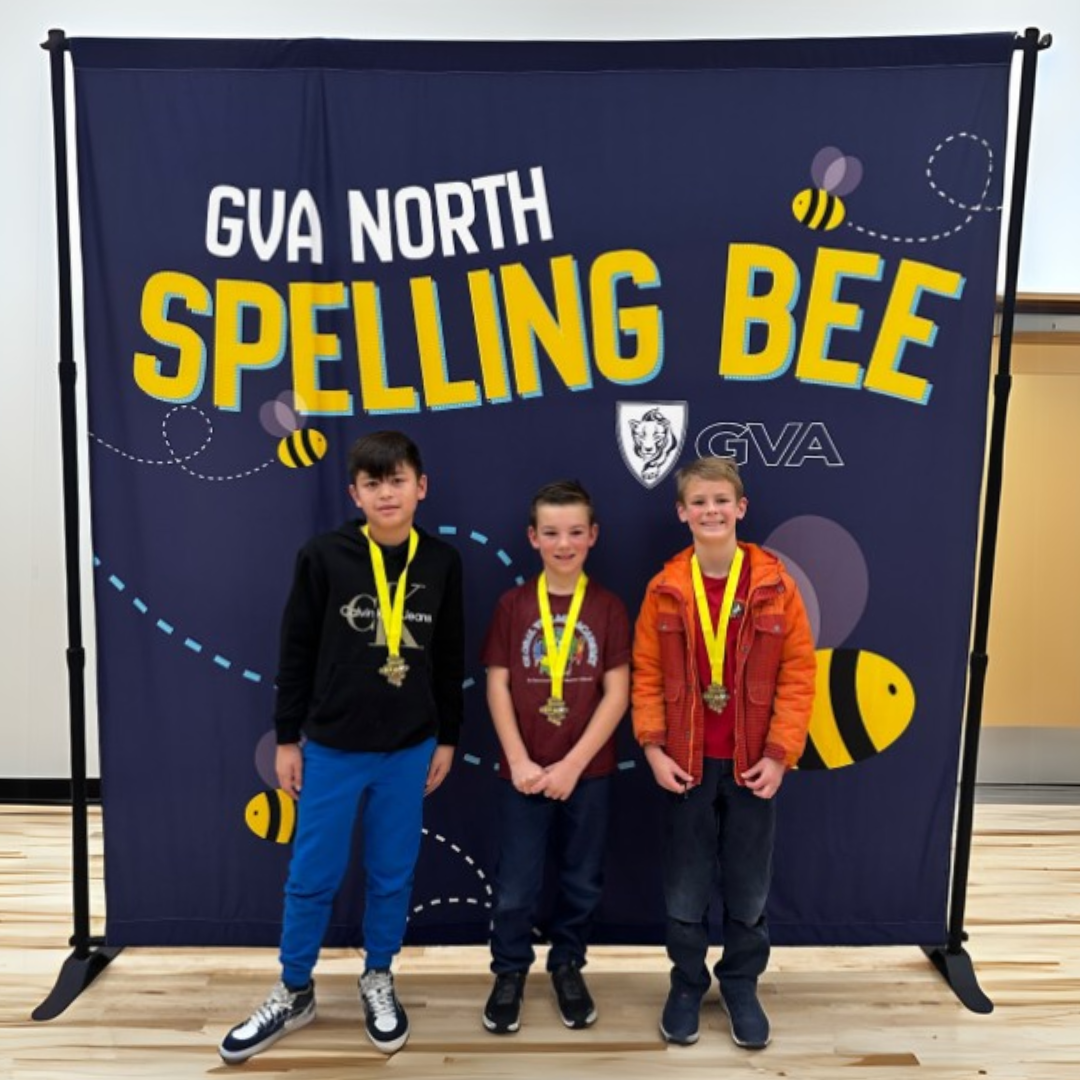 Spelling Bee Winners standing in front of GVA North Spelling Bee banner in the new gym