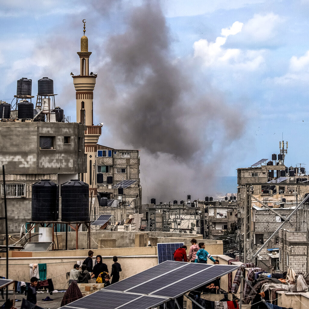 Smoke plumes above rooftops where some people have gathered in Rafah, in the southern Gaza Strip. 