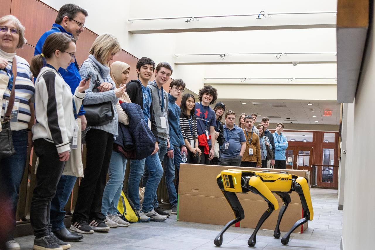 Photo of students observing a robot dog demonstration at Tulsa Time