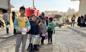 Niños haciendo cola para recibir comida caliente en Alepo, Siria.