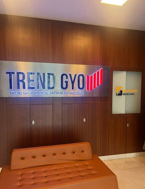 The Trend GYO office with a large branded sign hanging on a wood-paneled wall.