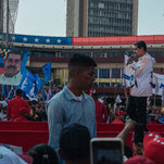 President Nicolás Maduro of Venezuela holds a microphone as he speaks to a crowd.