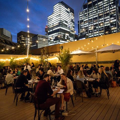 People at tables with city skyline in the background