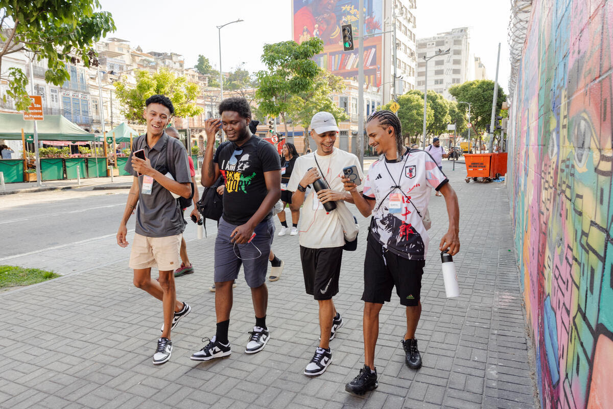 Four young men smile and walk down the street