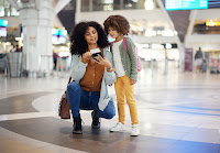 Travel, passport and mother with her child in the airport checking their boarding pass together.