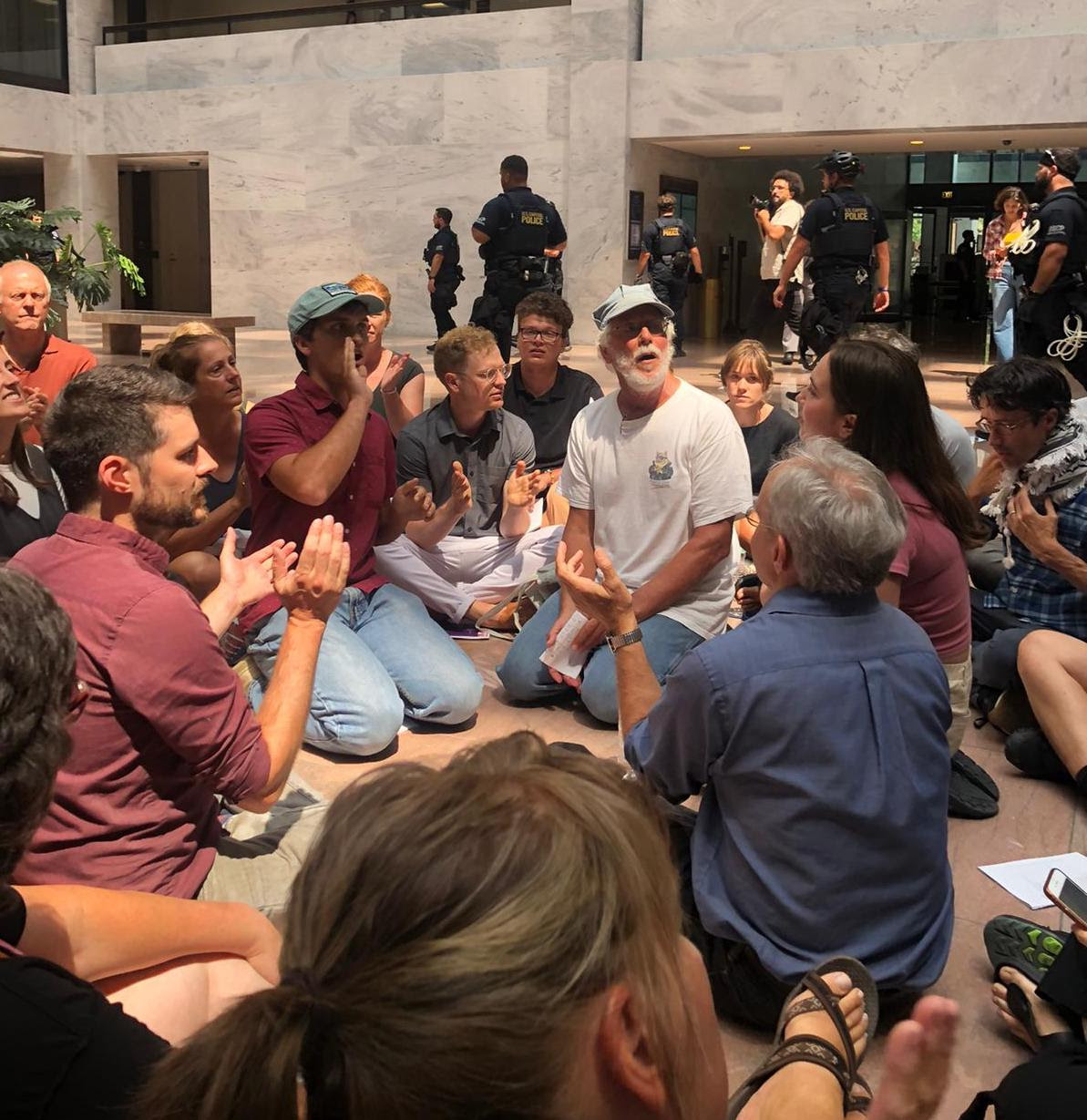 Mennonites and allies hold a peaceful protest in the Hart Senate building. Mennonites and allies hold a peaceful protest in the Hart Senate building.