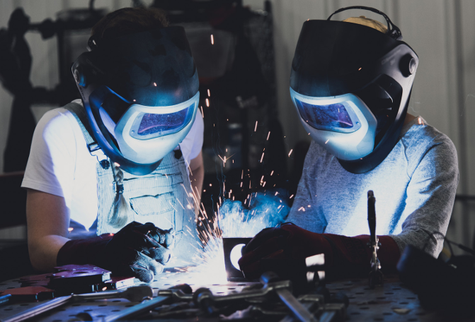 Two people learning how to weld