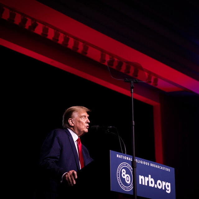Donald Trump, wearing a dark suit and red tie, speaks from behind a lectern adorned with the logo of the National Religious Broadcasters association.