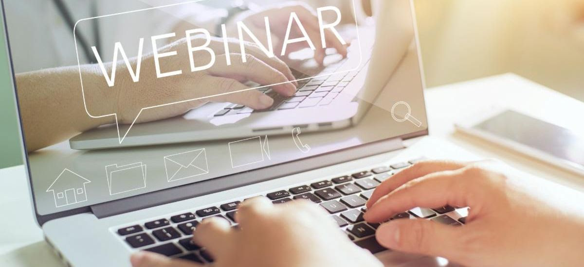 Image is a close up of a laptop with the word webinar on the screen.