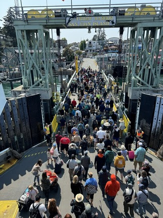 Several people walking off a ferry using the vehicle transfer span at Friday Harbor terminal