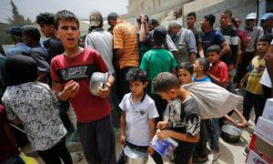 Niños esperando para conseguir comida en Gaza