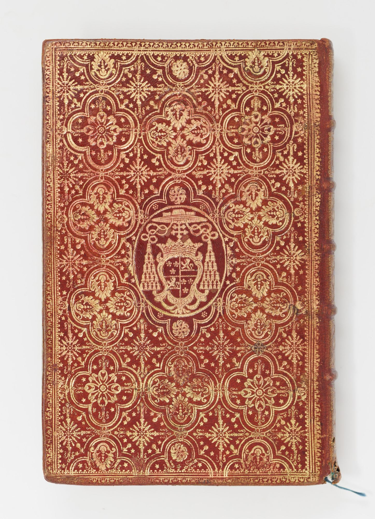 The red-and-gold fanfare binding of a 1727 Office of Holy Week, with the arms of a French cardinal at center