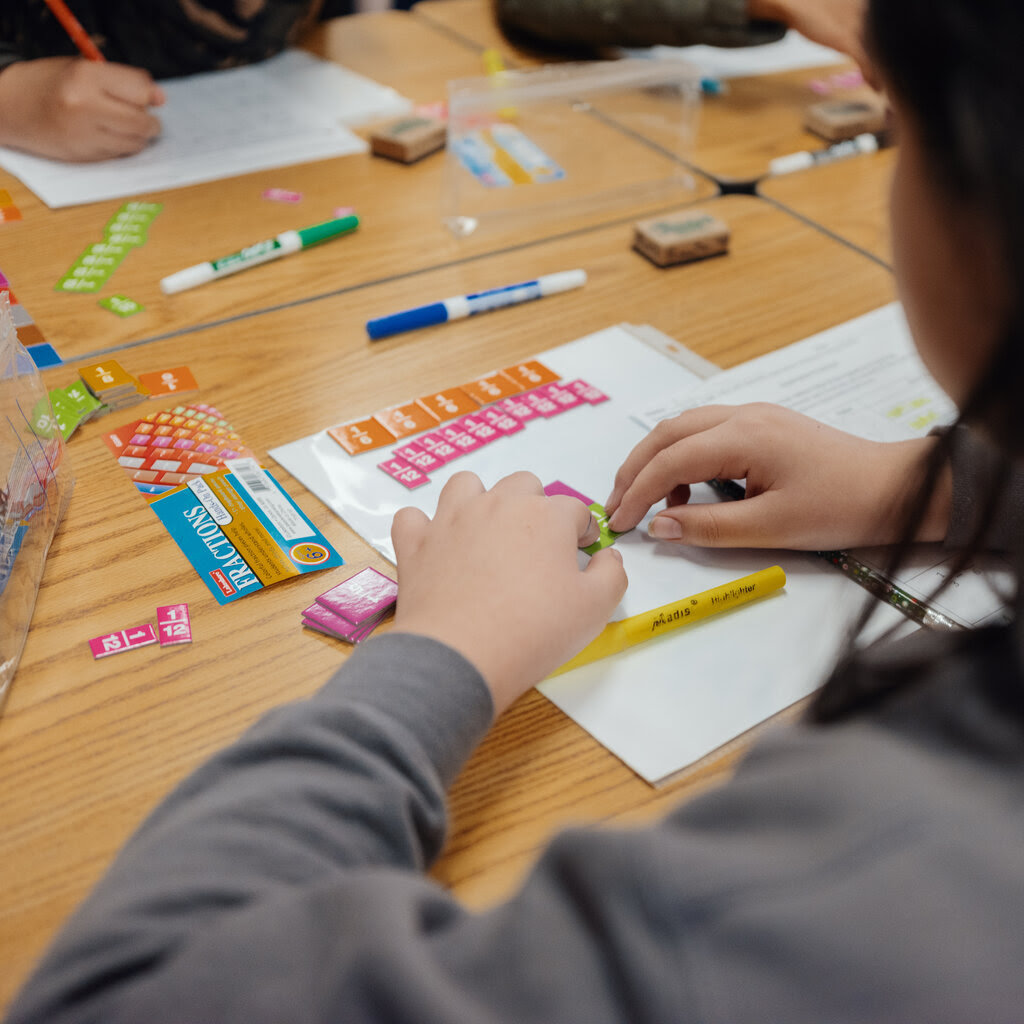 A fourth grader uses colorful stickers to practice fractions. 