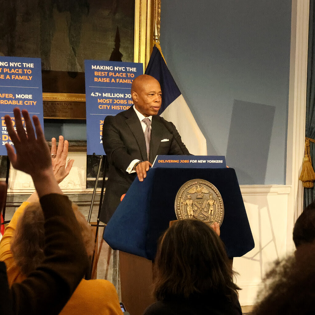 Eric Adams takes questions from behind a lectern.