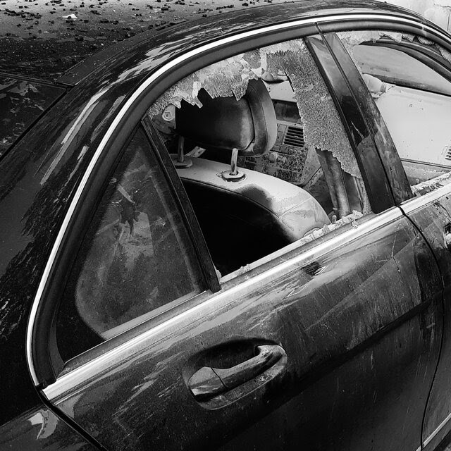 A car with its windows blown out.