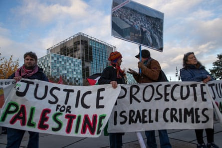 Demonstrators carry banners outside the ICC