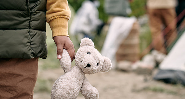 Homeless child holding a stuffed bear
