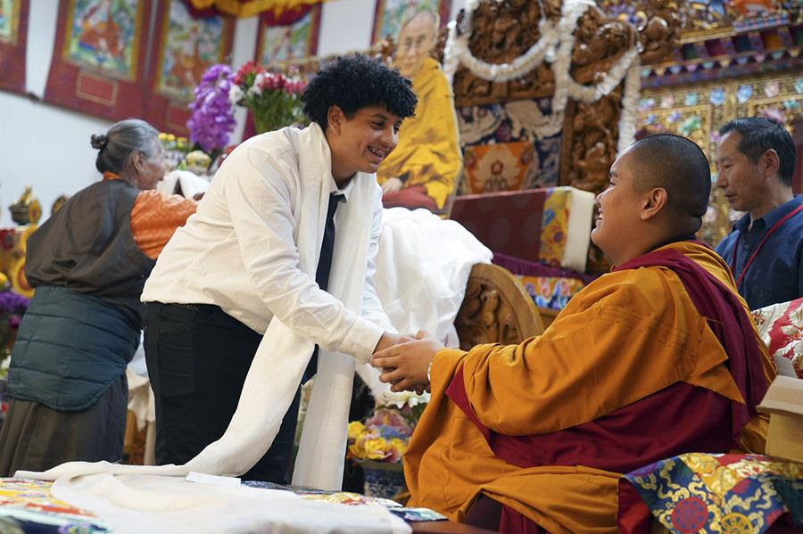 High school friends present U.S.-born Buddhist lama, Jalue Dorje, right, with a “khata,” the Tibetan ceremonial scarves that symbolize auspiciousness.