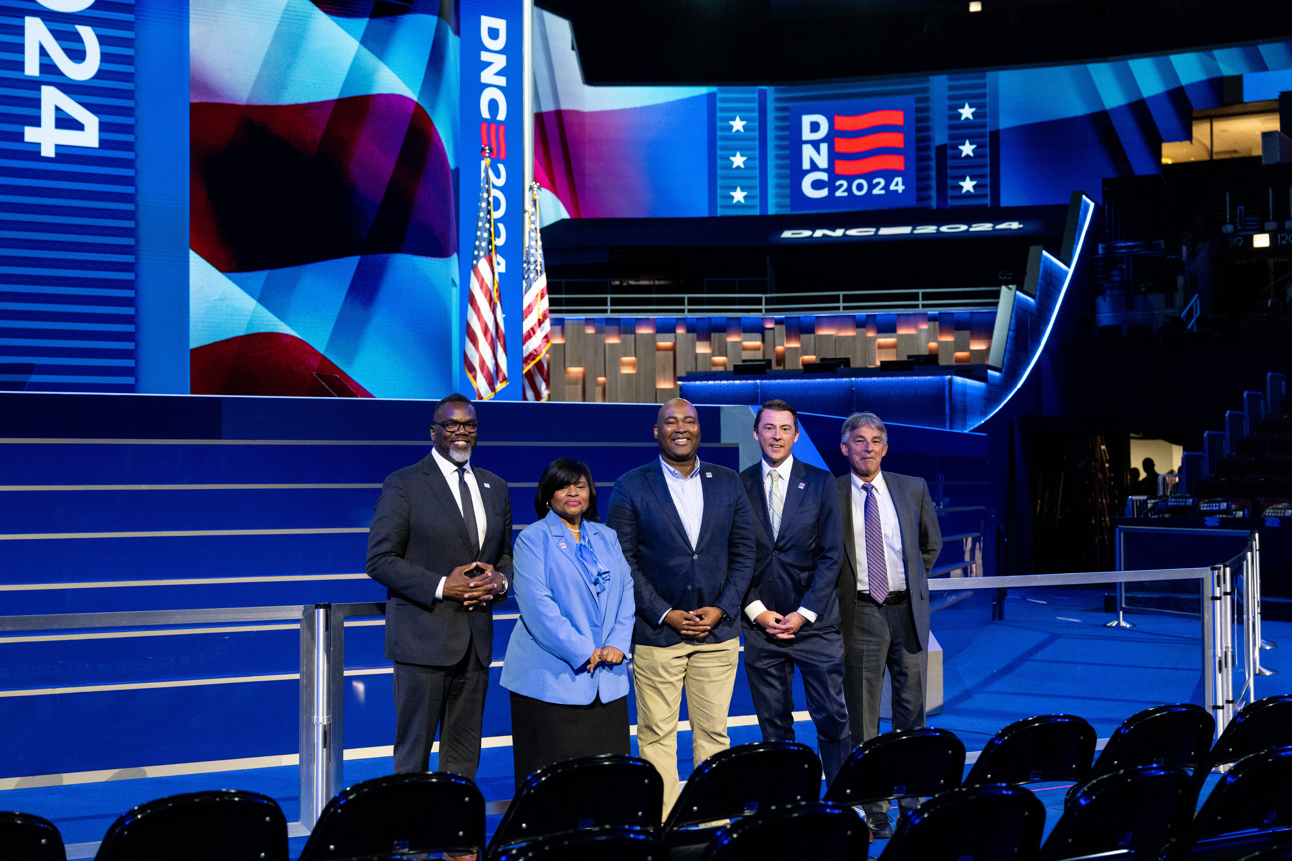 a group of speakers standing on in front of the Democratic National Convention stage