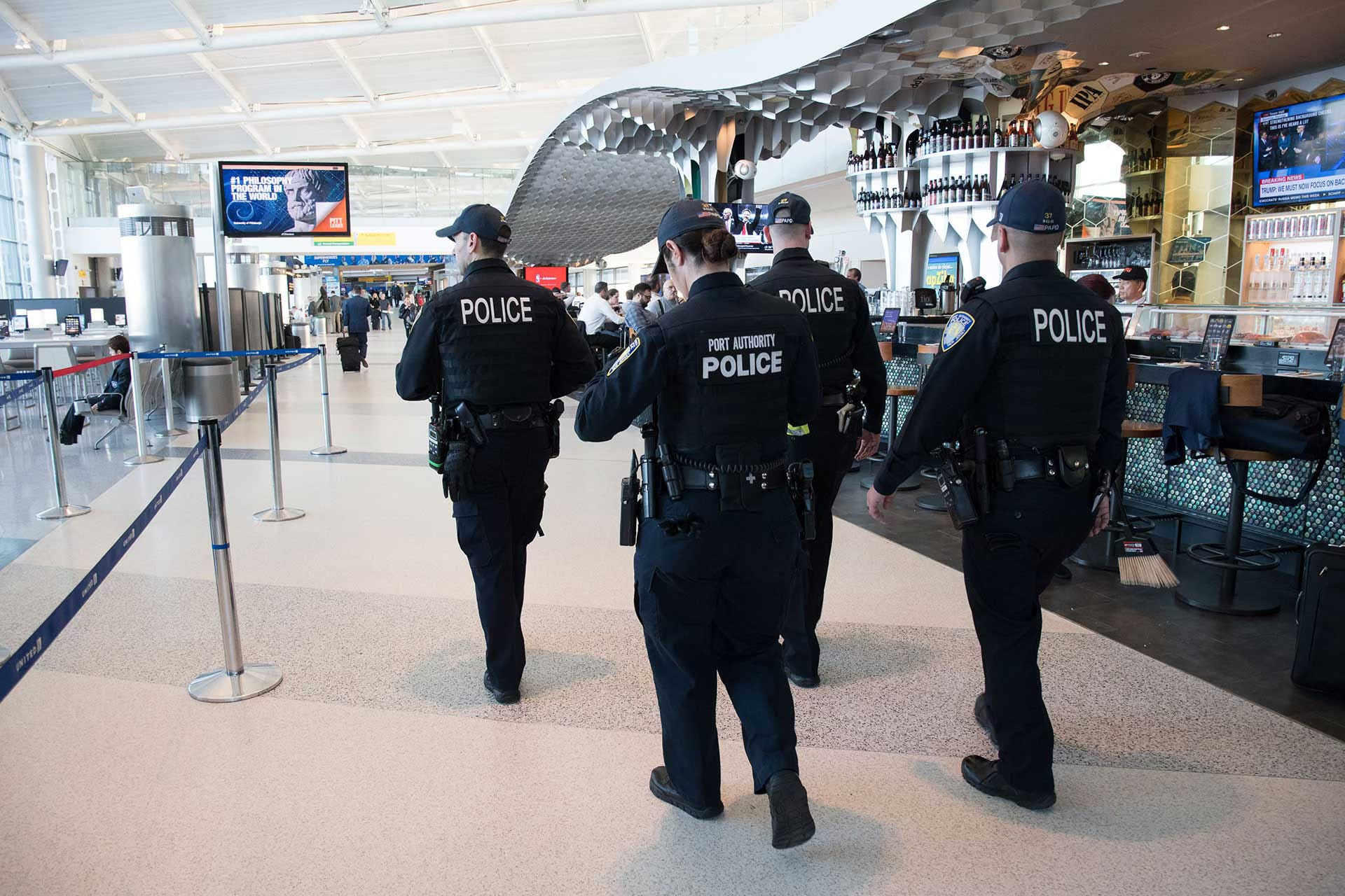 Police walking through airport terminal. Police walking through airport terminal.