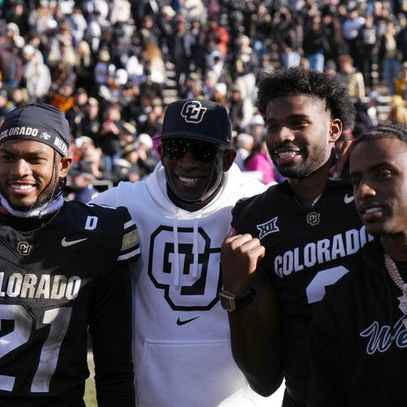 Colorado's Shilo Sanders (21), coach Deion Sanders, quarterback Shedeur Sanders and social media producer Deion Sanders Jr. pose together after a November game.