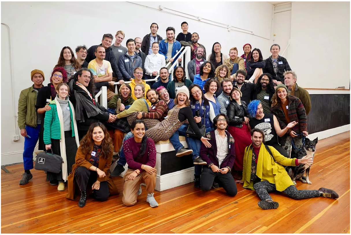 photo from the community living exchange blog post. group of ~30 people hugging and looking at the camera. source: https://supernuclear.substack.com/p/harnessing-collective-potential