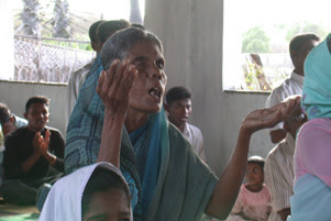 A woman is raising her hands in worship.