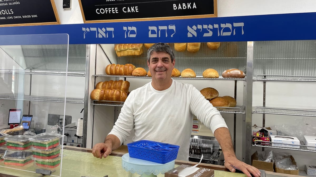 Owner Doug Weinstein stands behind the counter of Diamond Bakery on its last day in business. Photo by Robin Estrin.