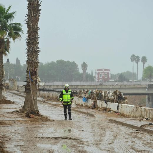 A firefighhter walks in an empty street during rain in Paiporta, south of Valencia, eastern Spain, on November 13, 2024 in the aftermath of deadly flooding. Spain closed schools and evacuated residents as heavy rains lashed the country on November 13, two weeks after its worst floods in a generation killed more than 200 people. (Photo by JOSE JORDAN / AFP)