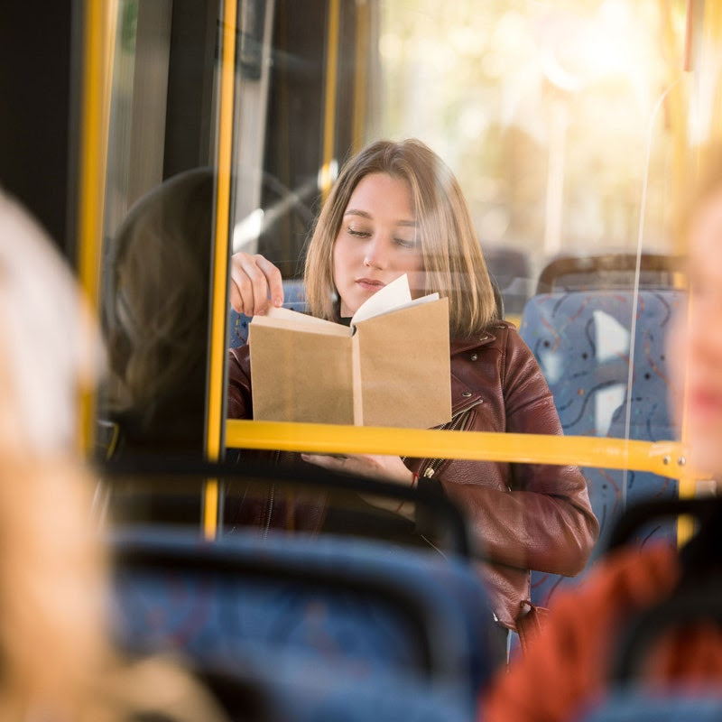 Woman reading a book on a bus