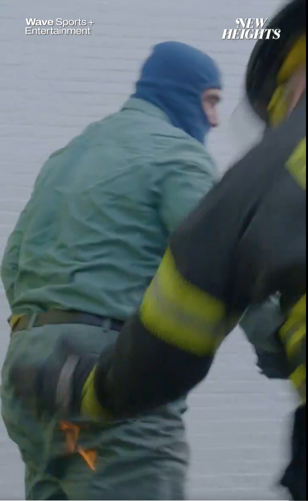 A firefighter brushes flames off of former Philadelphia Eagles center Jason Kelce. Screenshot/Twitter/@newheightsshow