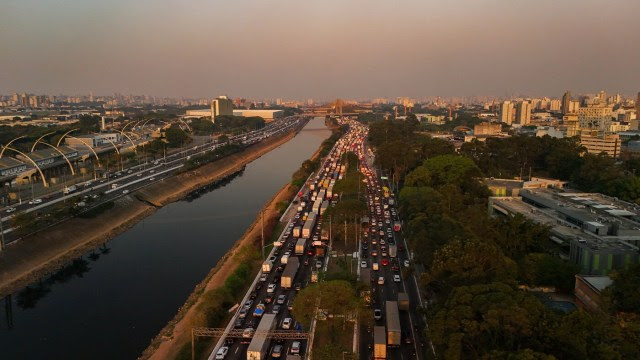 Imagem aérea mostra trânsito em avenida de São Paulo e céu coberto por poluição; qualidade do ar na cidade bate recordes negativos