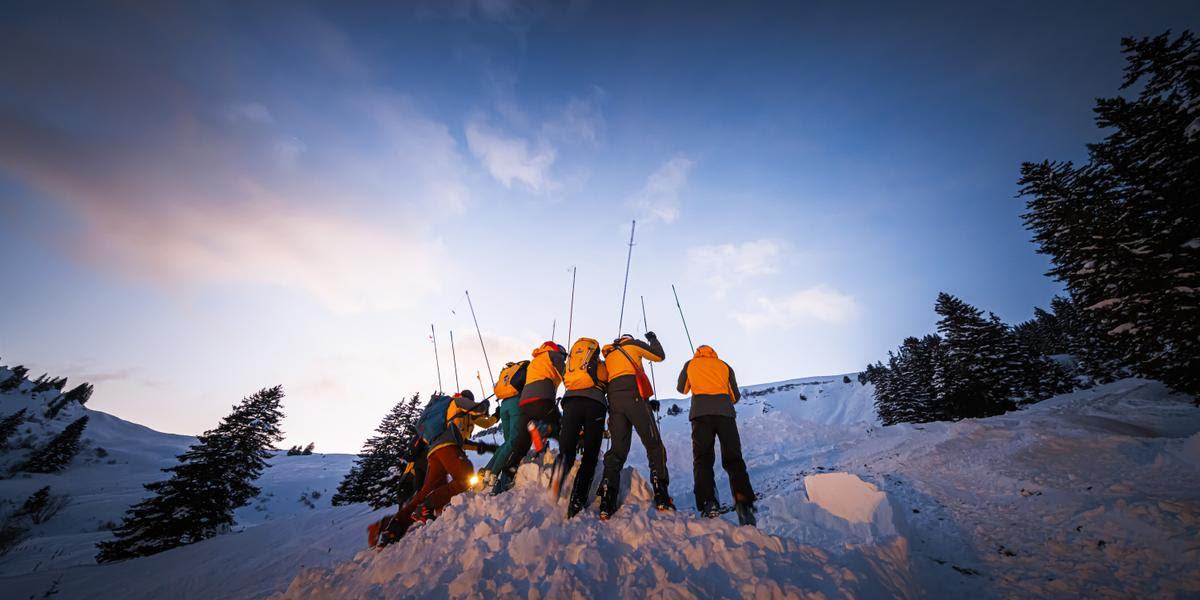 Des secouristes sondent le terrain lors d'un exercice avalanche organise par les sauveteurs du Secours alpin romand (SARO) avec la participation entre autres de la Rega, des pompiers et de la gendarmerie, ce samedi 21 janvier 2023 proche du domaine skiable des Diablerets. (KEYSTONE/Valentin Flauraud)