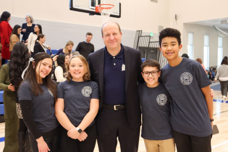 Four GVA students standing with Governor Jared Polis in the new gym