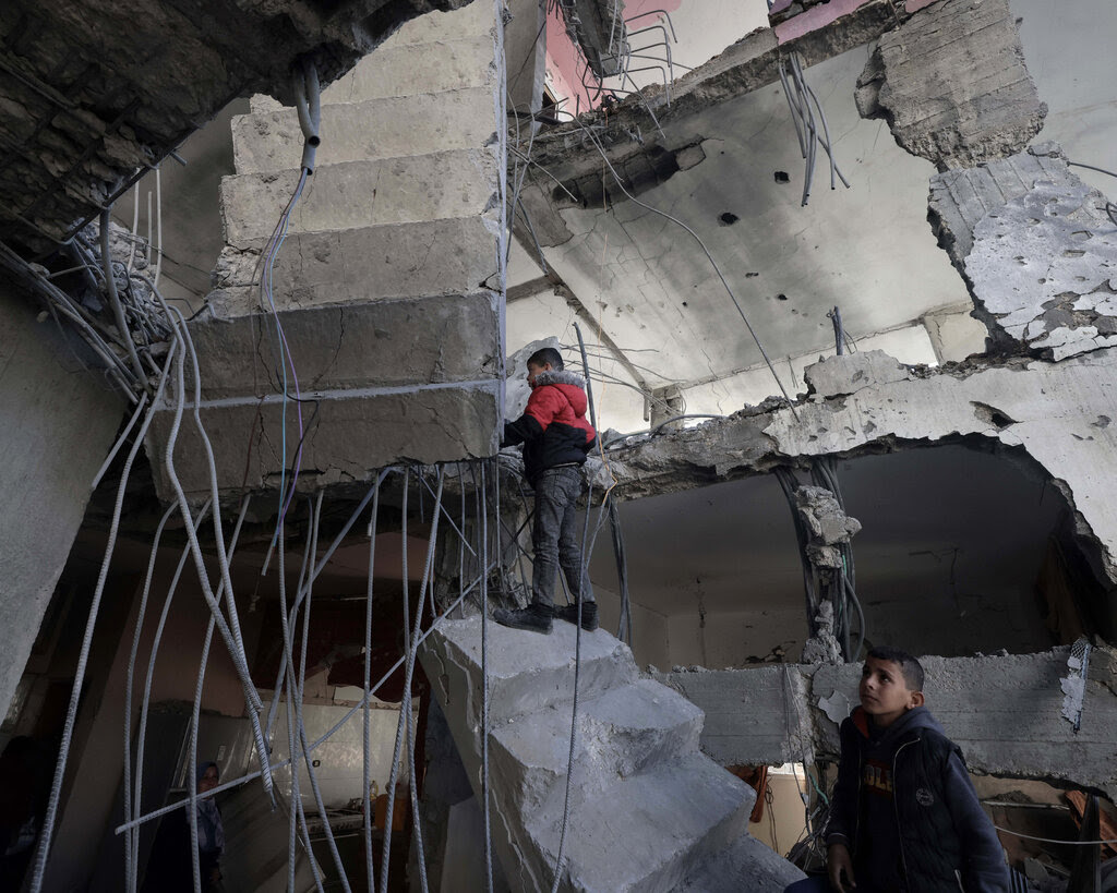 Palestinians inspect a damaged staircase inside a building in Rafah.