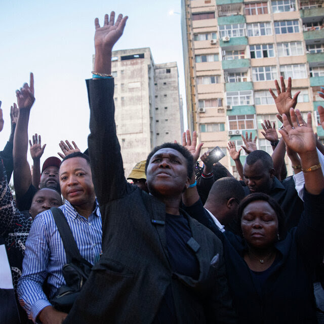 A group of people reaching toward the sky. 