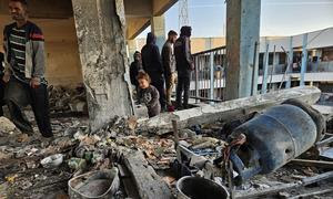 Varias personas miran entre los escombros de un edificio en Khan Younis, Gaza.