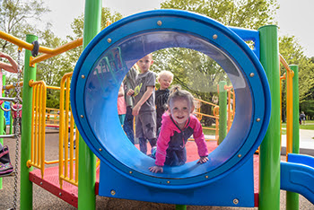 Children enjoy playing at an accessible playground.