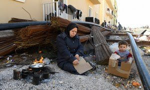 Una madre y su niño hierven unos huevos en un albergue a las afueras de Damasco (archivo).