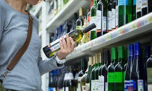 Una mujer observa una botella de vino en un supermercado de Moscú.